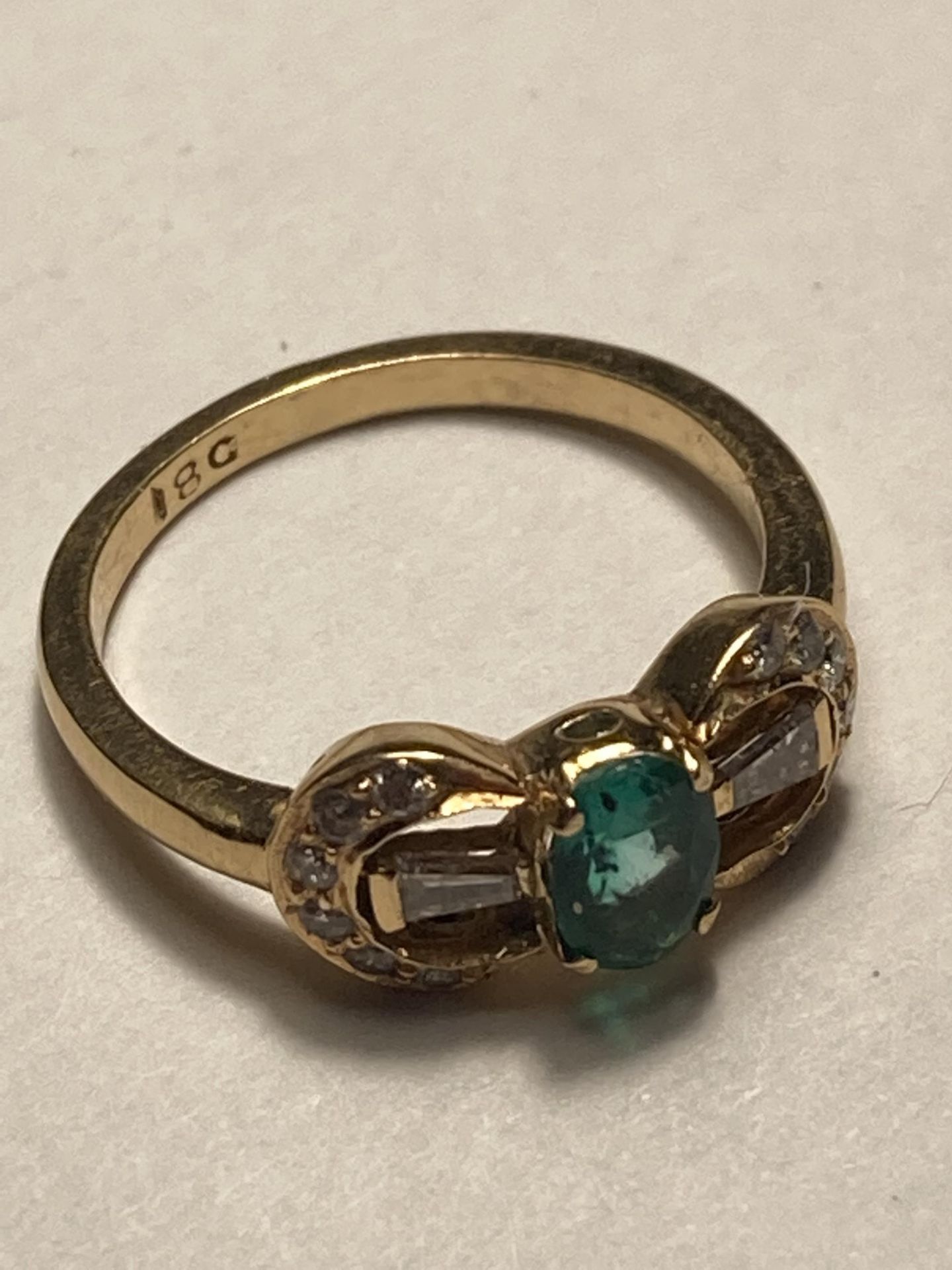 A 18 CARAT GOLD RING WITH A CENTRE GREEN STONE AND DIAMONDS SIZE J/K