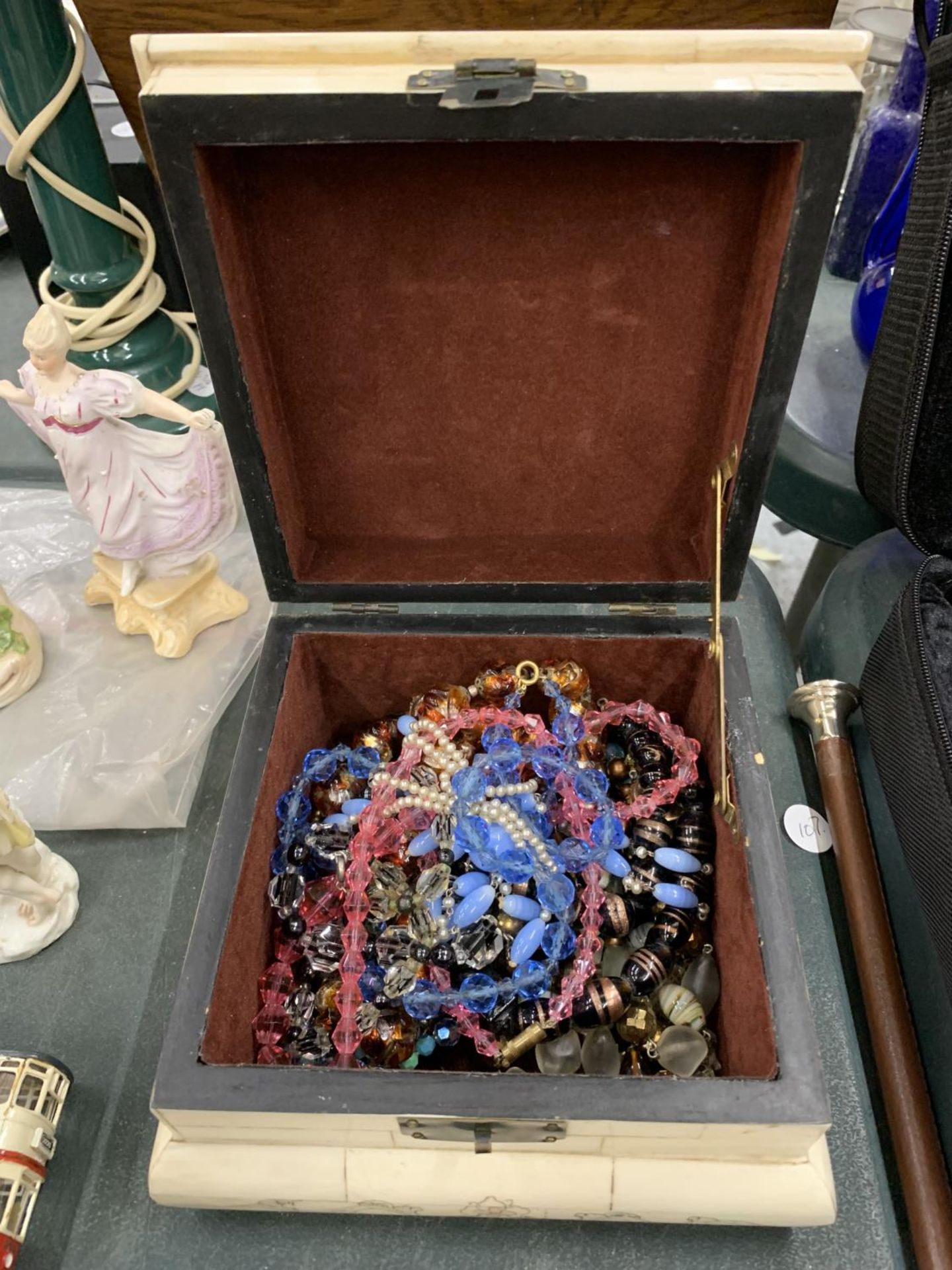 A QUANTITY OF GLASS NECKLACES IN A VINTAGE DECORATIVE BOX