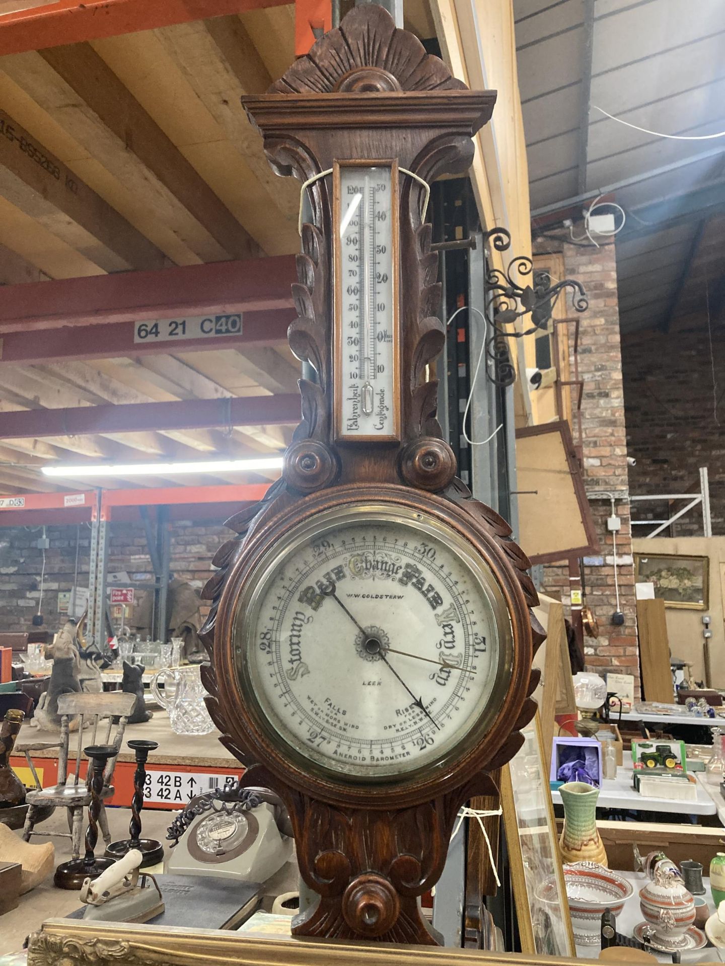 A W W GOLDSTRAW ANEROID BAROMETER IN A CARVED MAHOGANY CASE