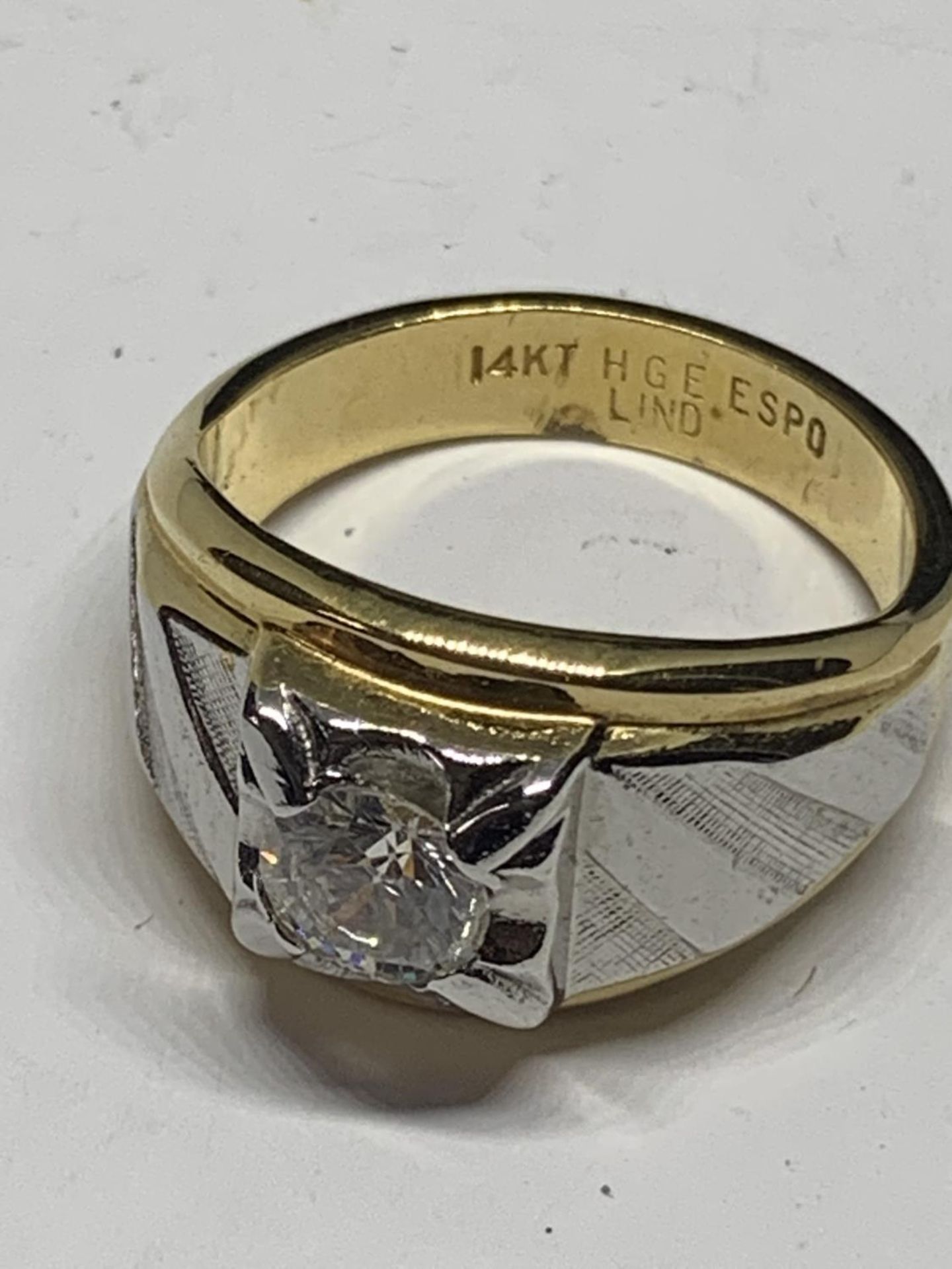 A GENTS RING WITH A CLEAR STONE IN A PRESENTATION BOX