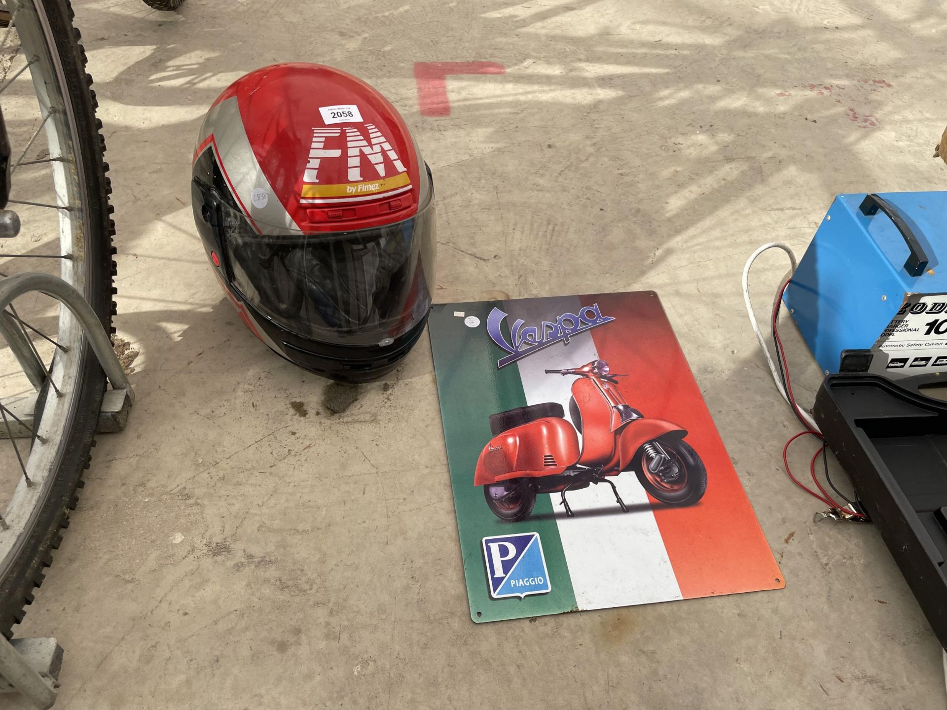 A VESPA TIN SIGN AND A SCOOTER HELMET