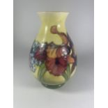 A WALTER MOORCROFT FLORAL ORCHID PATTERN BALUSTER VASE ON YELLOW GROUND (SOME CRAZING)