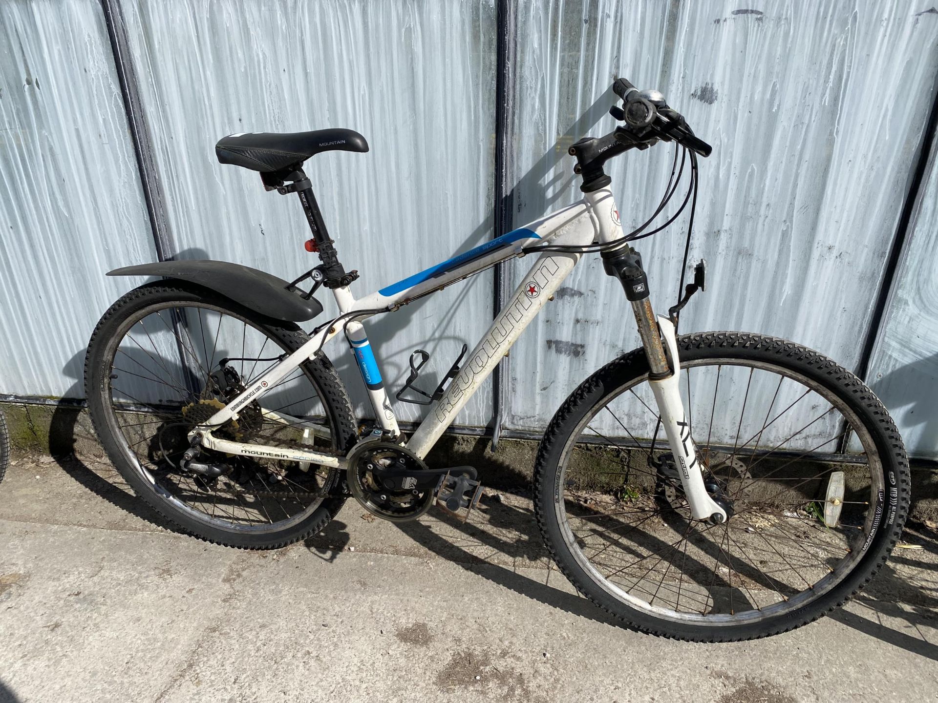 A REVOLUTION MOUNTAIN BIKE WITH FRONT SUSPENSION, DISC BRAKES AND A 24 SPEED SHIMANO GEAR SYSTEM