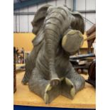 A LARGE MODEL OF A SEATED ELEPHANT