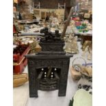 A VINTAGE MINIATURE CAST FIREPLACE WITH POKER HEIGHT 31CM, WIDTH 19CM