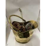 A VINTAGE HAMMERED EFFECT BRASS COAL BUCKET FILLED WITH PINE CONES
