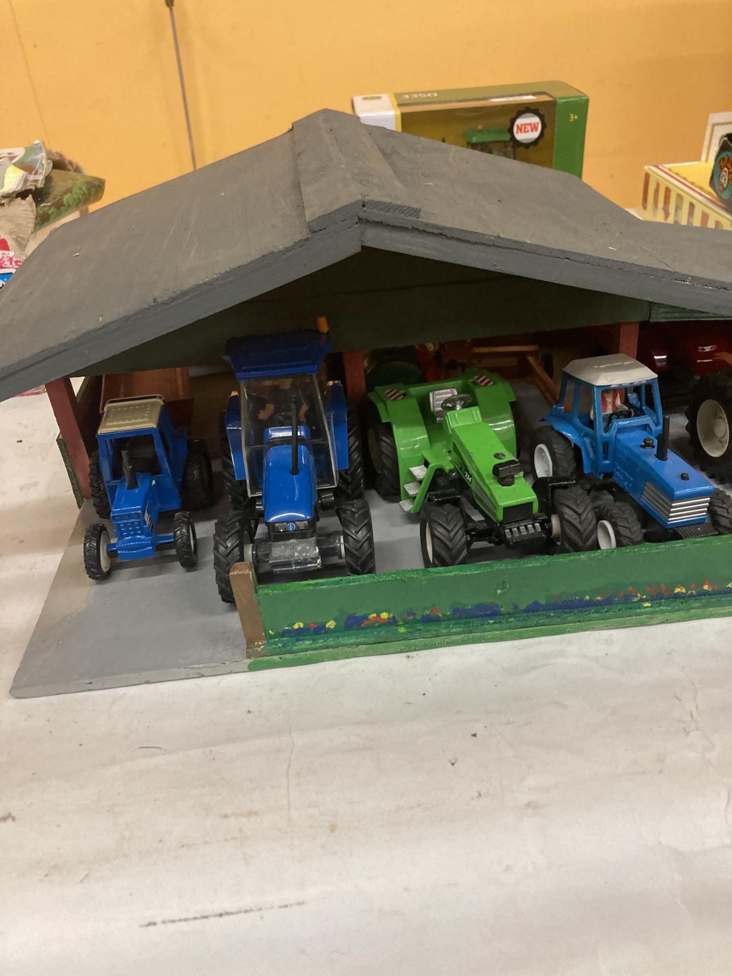 A WOODEN TRACTOR GARAGE CONTAINING A QUANTITY OF TRACTORS AND TRAILERS - Image 2 of 3