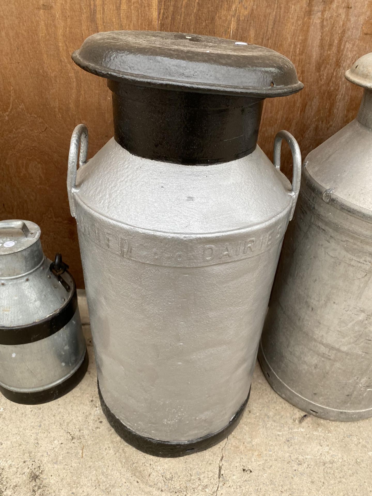 AN ALUMINIUM 'UNITED DAIRIES' MILK CHURN COMPLETE WITH LID