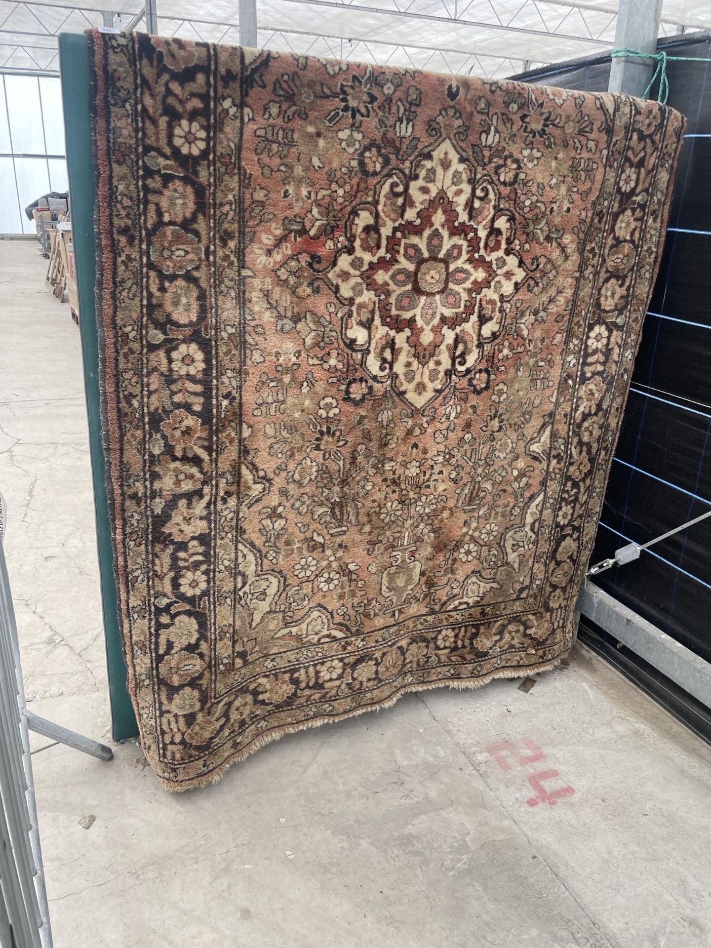 A VINTAGE HAND KNOTTED RED PATTERNED FRINGED RUG