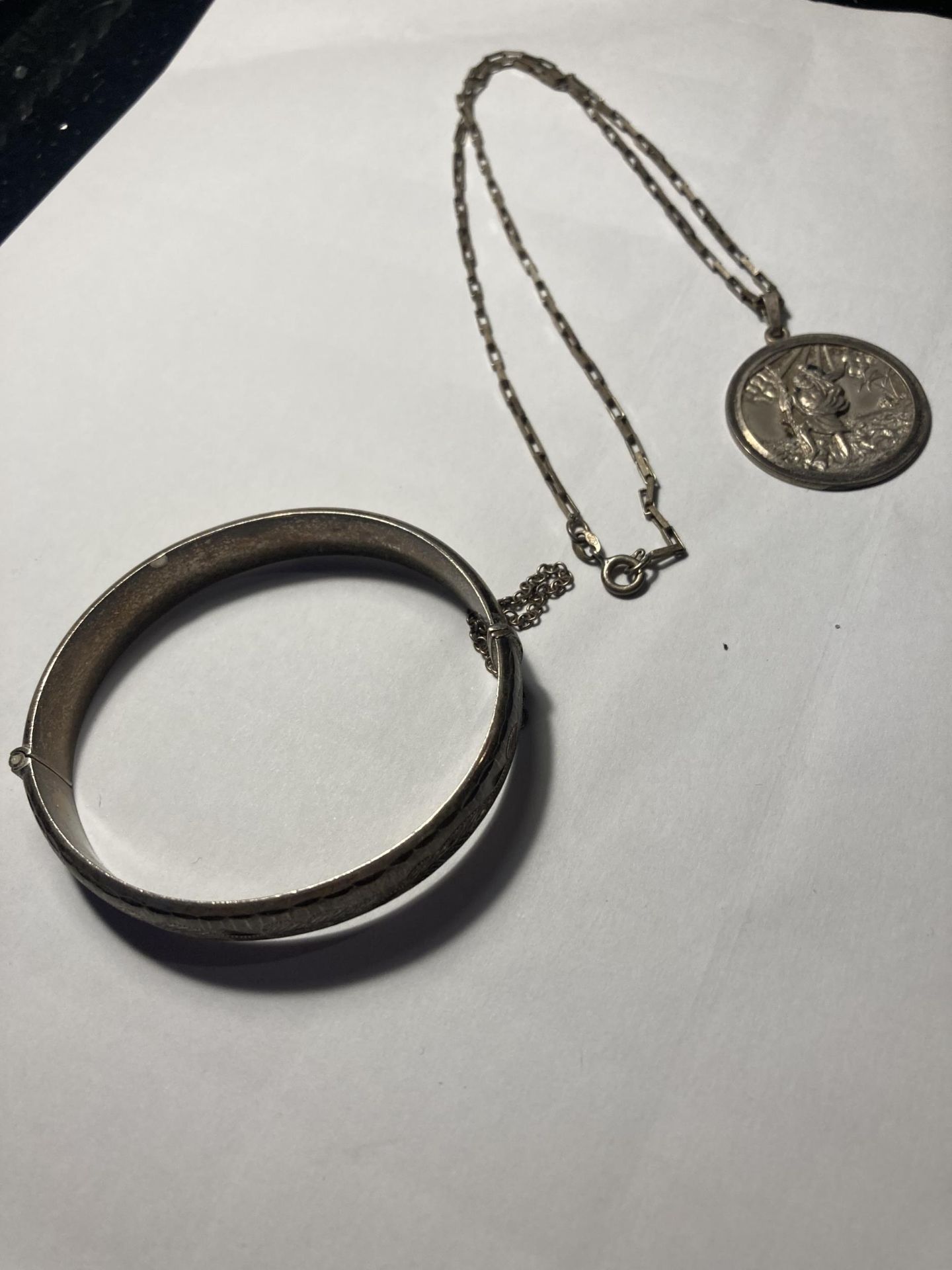TWO MARKED SILVER ITEMS TO INCLUDE A BANGLE WITH SAFETY CHAIN AND A NECKLACE WITH ST CHRISTOPHER