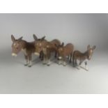 A GROUP OF FOUR BESWICK DONKEY FIGURES, ONE LEG A/F