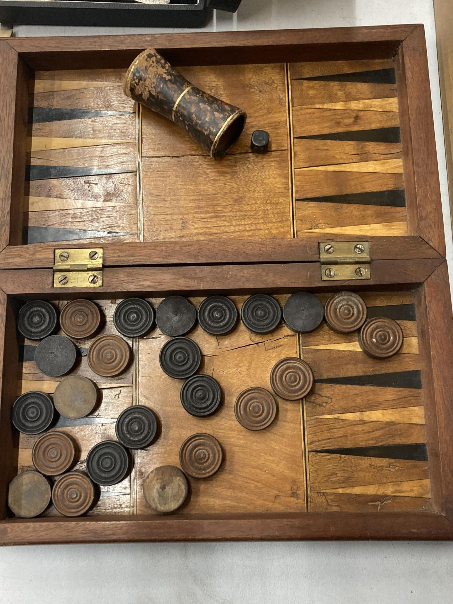 A FOLDING CHESS/BACKGAMMON BOX WITH COUNTERS, DICE AND SHAKER