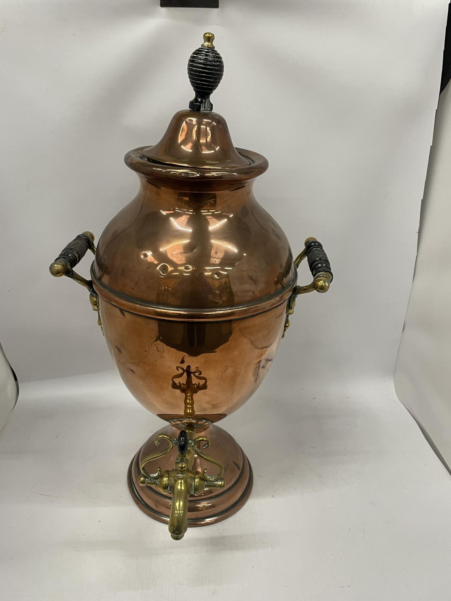 AN EARLY 20TH CENTURY TWIN HANDLED COPPER SAMOVAR URN WITH BRASS TAP