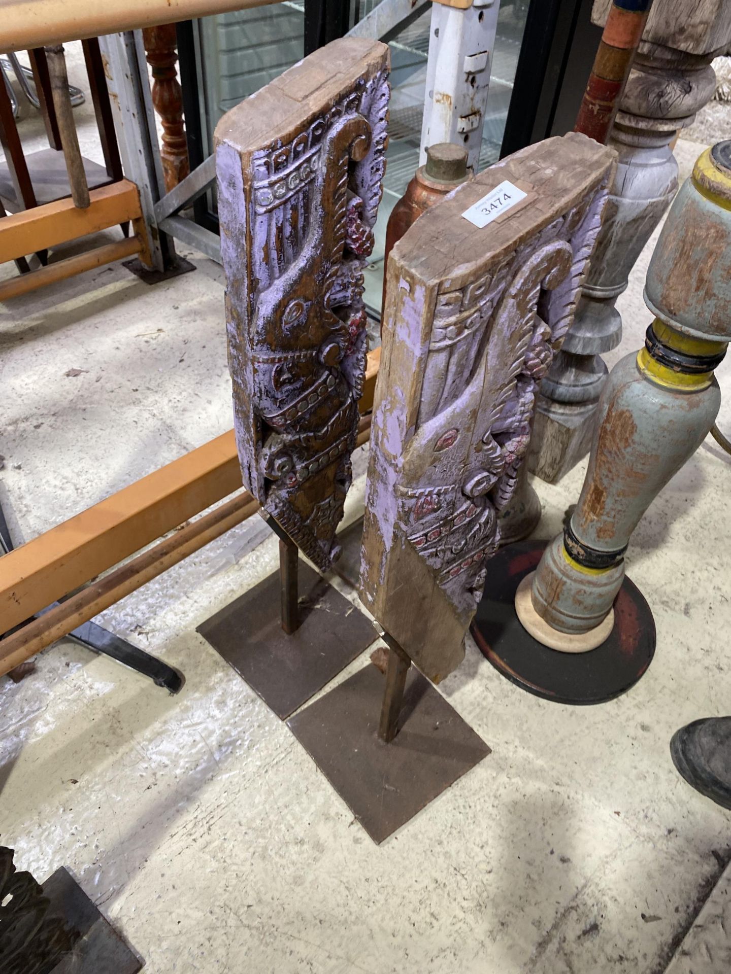 A PAIR OF INDIAN HARDWOOD CARVED PLAQUES ON STANDS