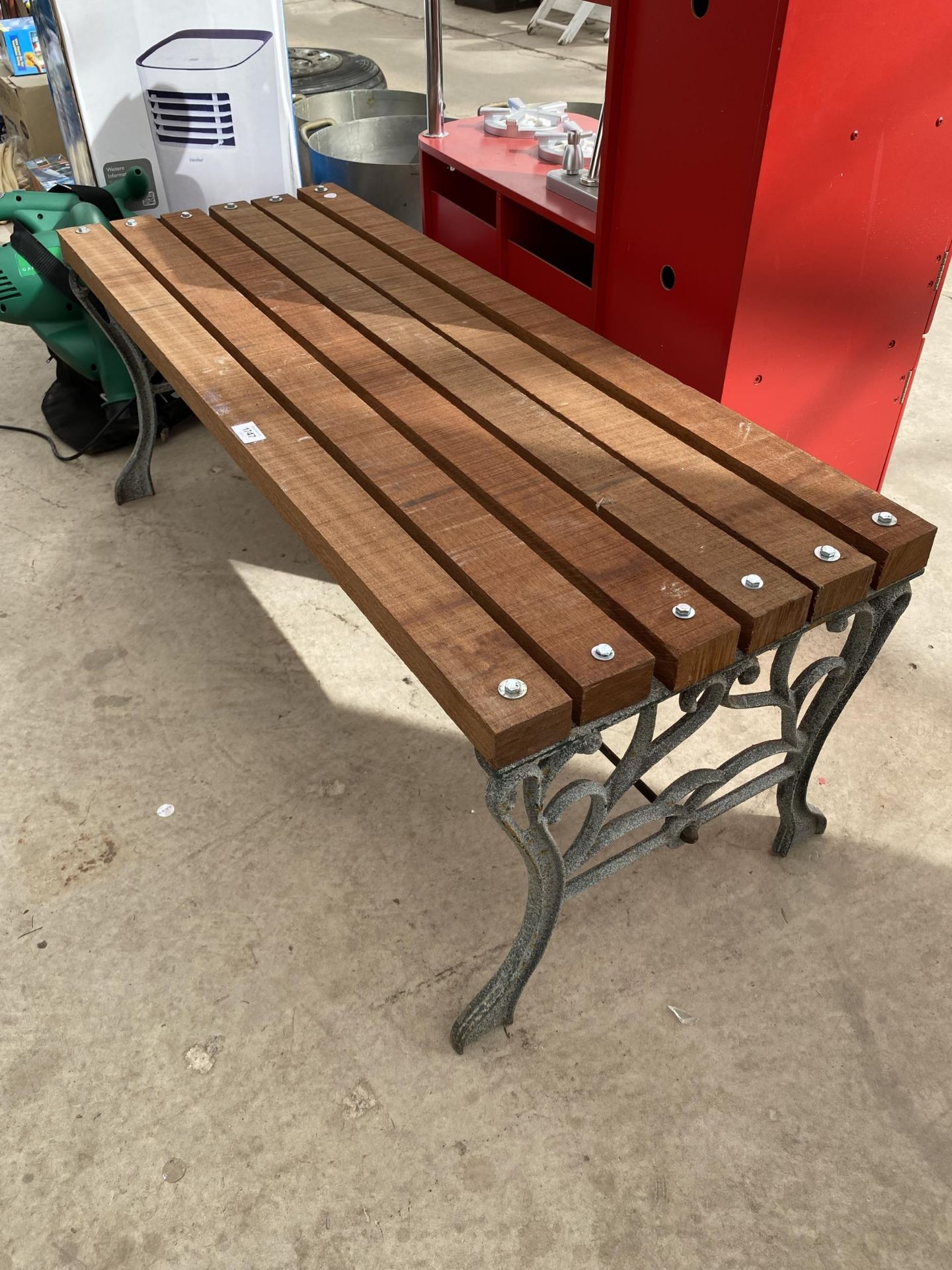 A WOODEN SLATTED BENCH WITH CAST BENCH ENDS