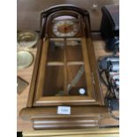 A HERMLE PENDULUM WALL CLOCK ENCASED IN MAHOGANY AND GLASS PANEL