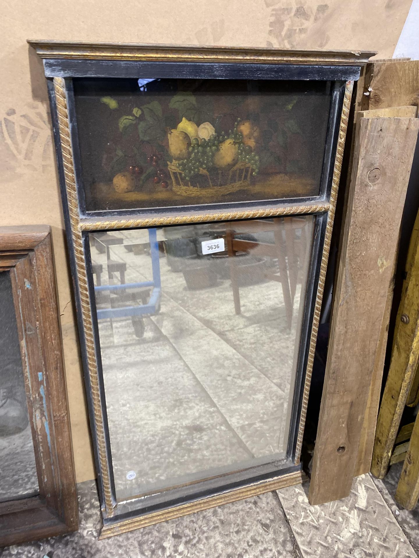 A VINTAGE GILT AND EBONISED MIRROR WITH STILL LIFE PAINTED SCENE