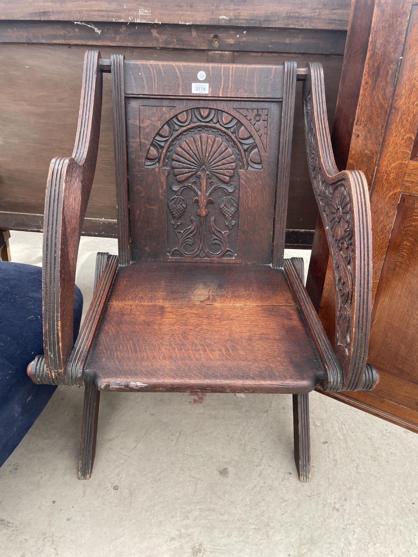 AN OAK LATE 19TH CENTURY GLASTONBURY TYPE CHAIR WITH CARVED BACK PANEL