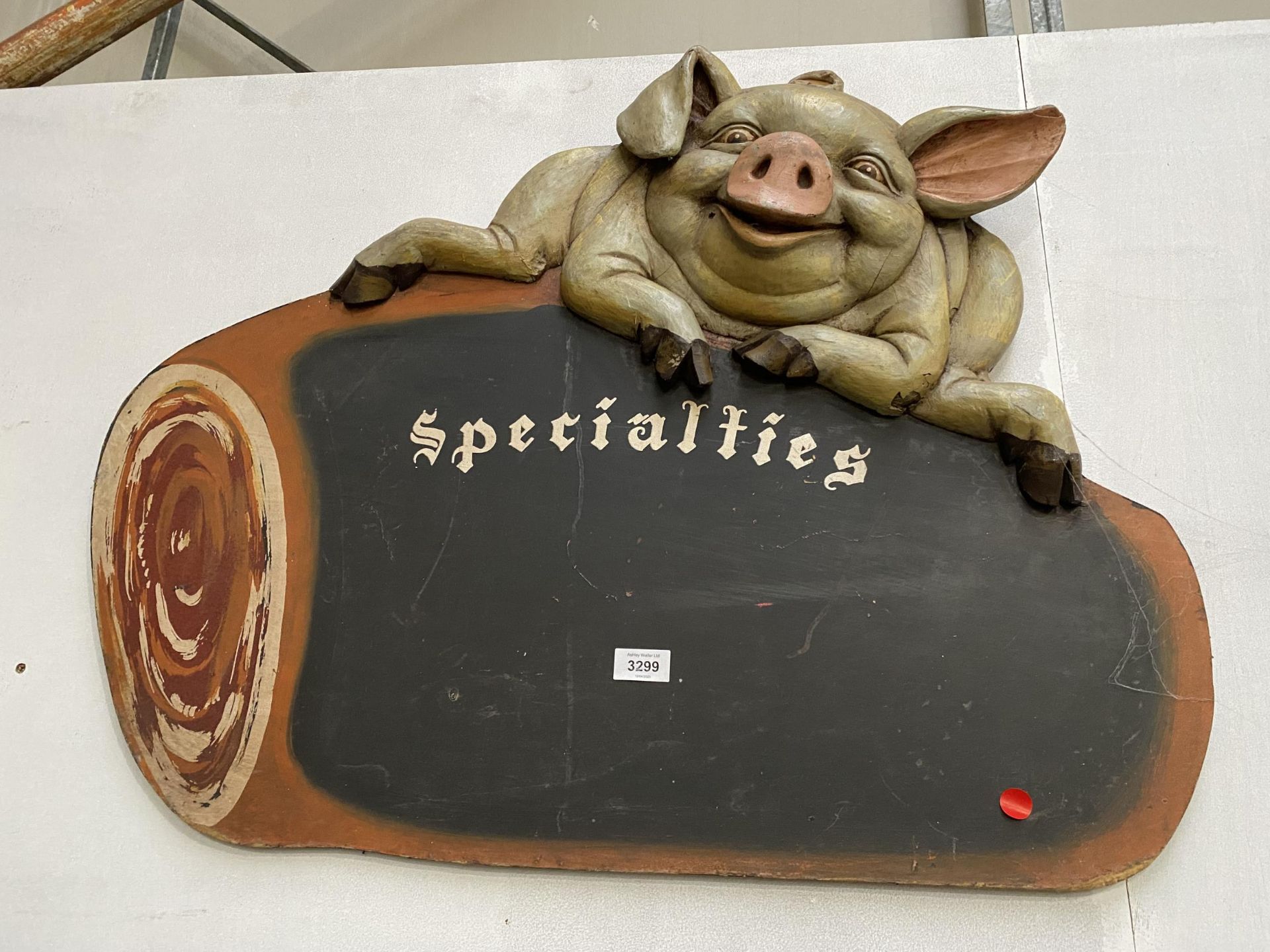 A RESTAURANT CHALK BOARD 'SPECIALITIES' DECORATED WITH SMILING PIG