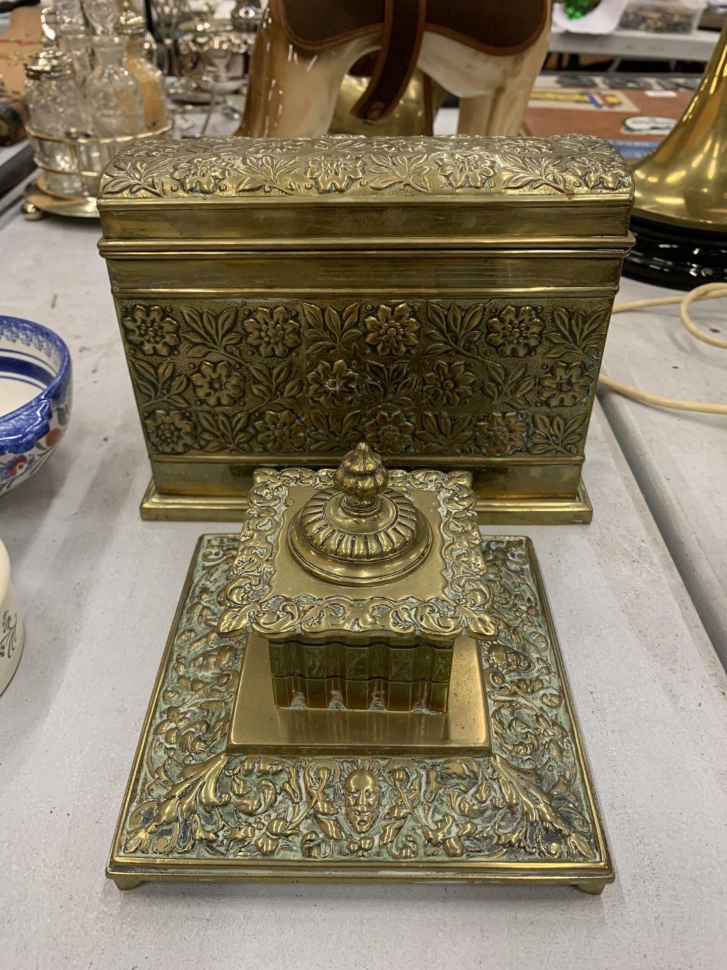 AN ASIAN STYLE BRASS STATIONERY BOX WITH COMPARTMENTS AND INKWELL WITH GLASS LINER, BOTH WITH FLORAL