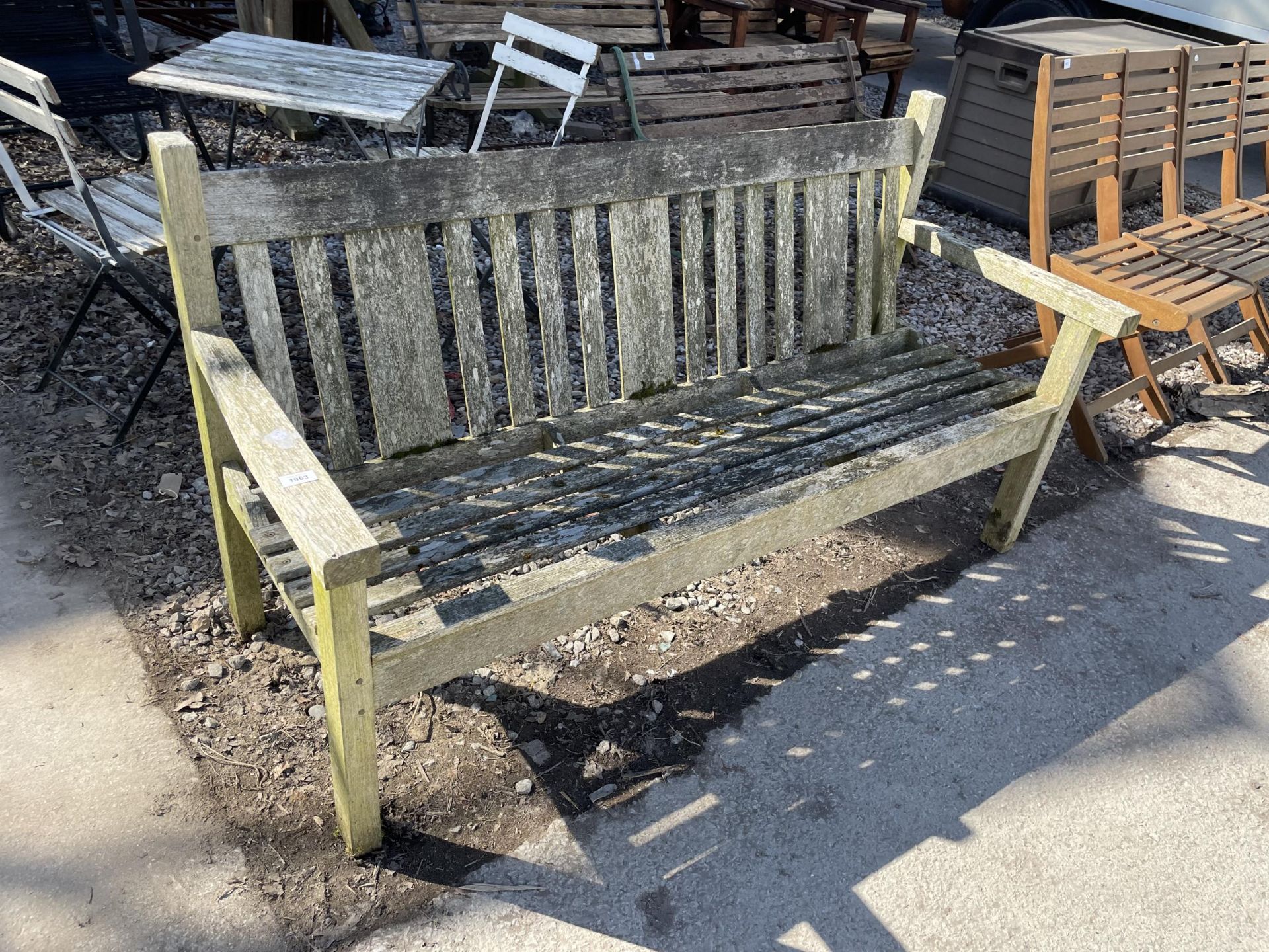 A WOODEN SLATTED THREE SEATER GARDEN BENCH