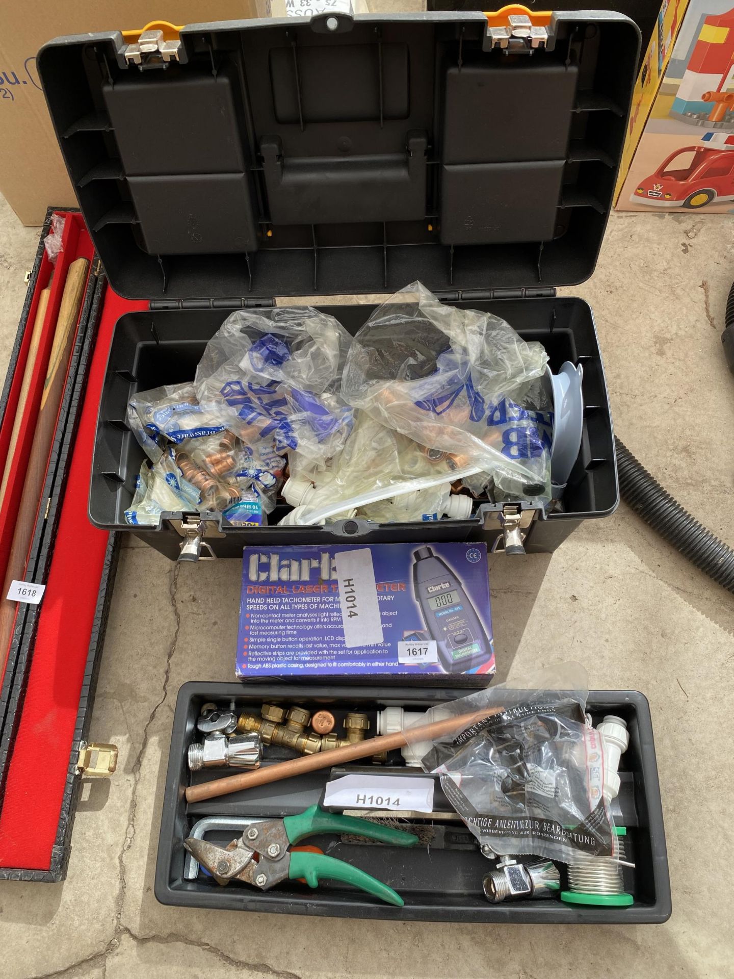 A PLASTIC TOOL BOX AND AN ASSORTMENT OF TOOLS TO INLCUDE A CLARKE DIGITAL LASER TESTER, PIPE