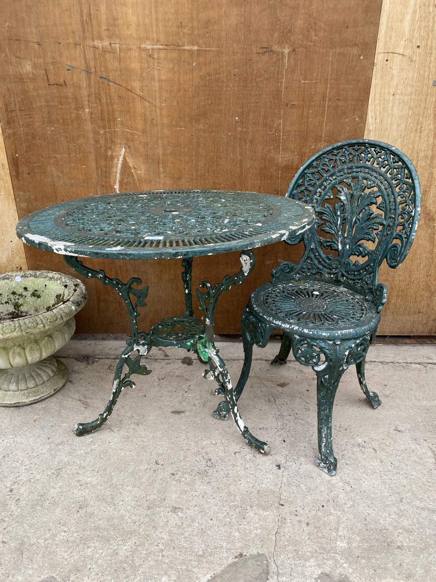 A CAST ALLOY BISTRO SET COMPRISING OF A ROUND TABLE AND ONE CHAIR