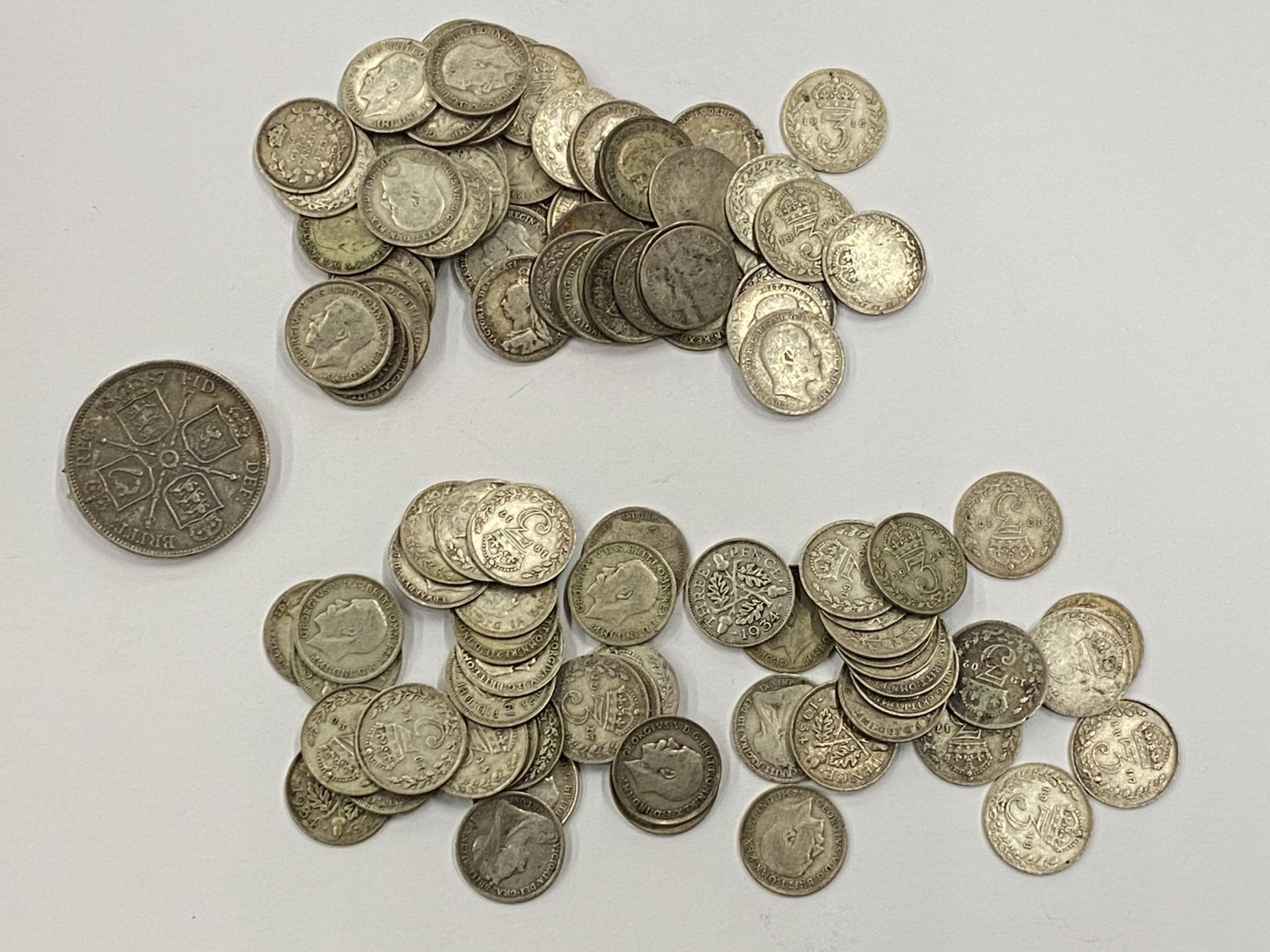 A LEATHER WALLET OF MAINLY PRE 1920 SILVER THREEPENCES AND A VICTORIAN 1887 COIN BROOCH