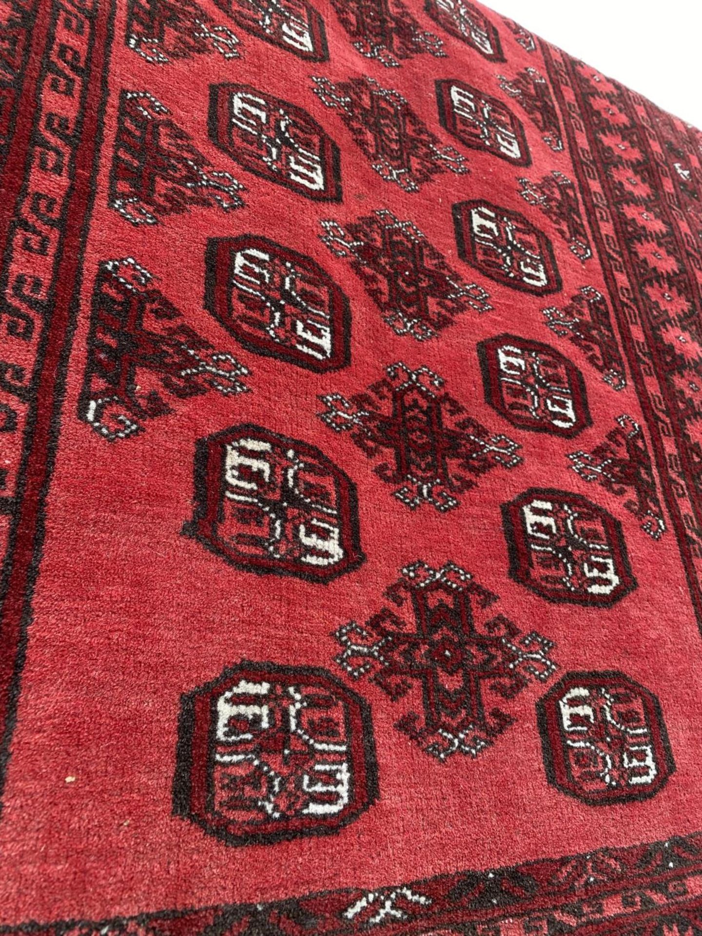 A RED PATTERNED FRINGED RUG (185CM x 107CM) - Image 2 of 3