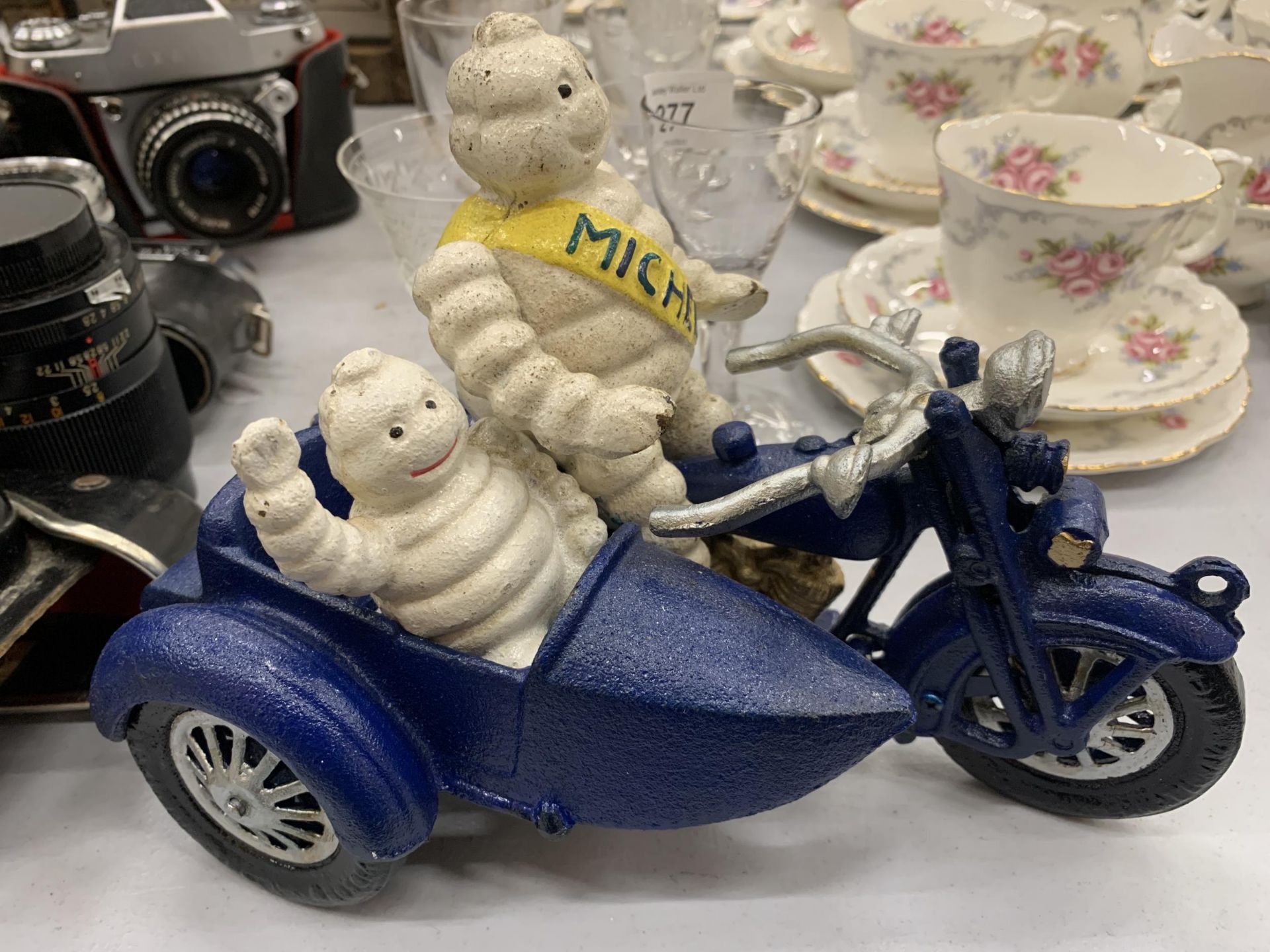 A CAST MICHELIN MAN ON A MOTOR BIKE WITH A SIDE CAR