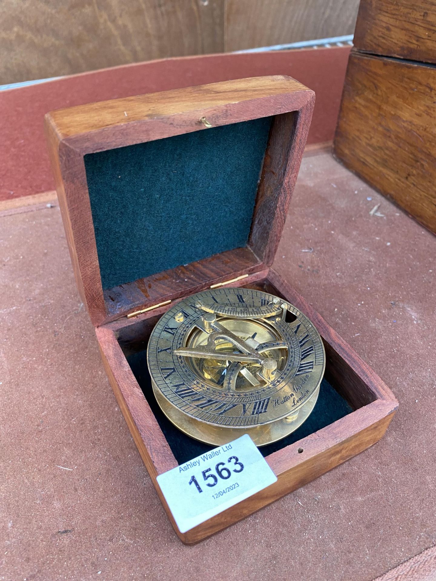 A VINTAGE BRASSS COMPASS BEARING THE STAMP' HATTON GARDEN LONDON' COMPLETE WITH WOODEN CASE