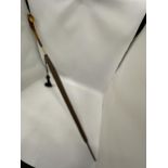 A VINTAGE PARASOL WITH DECORATIVE YELLOW METAL FERRULE AND AMBER EFFECT HANDLE