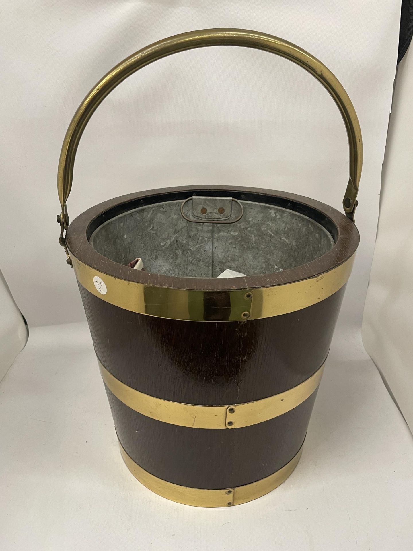 A VINTAGE OAK AND BRASS BOUND BUCKET WITH BRASS HANDLE AND INNER GALVANISED LINER