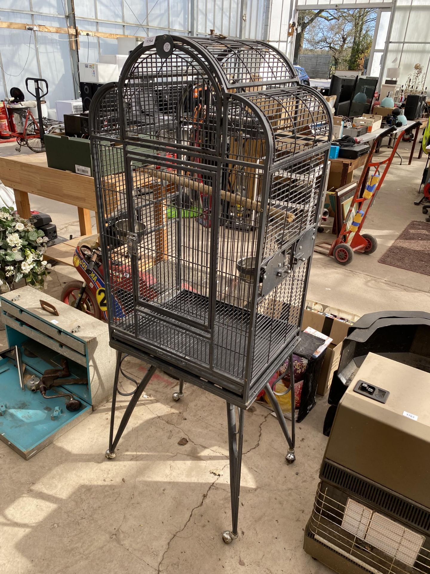 A LARGE METAL PARROT CAGE ON WHEELED BASE