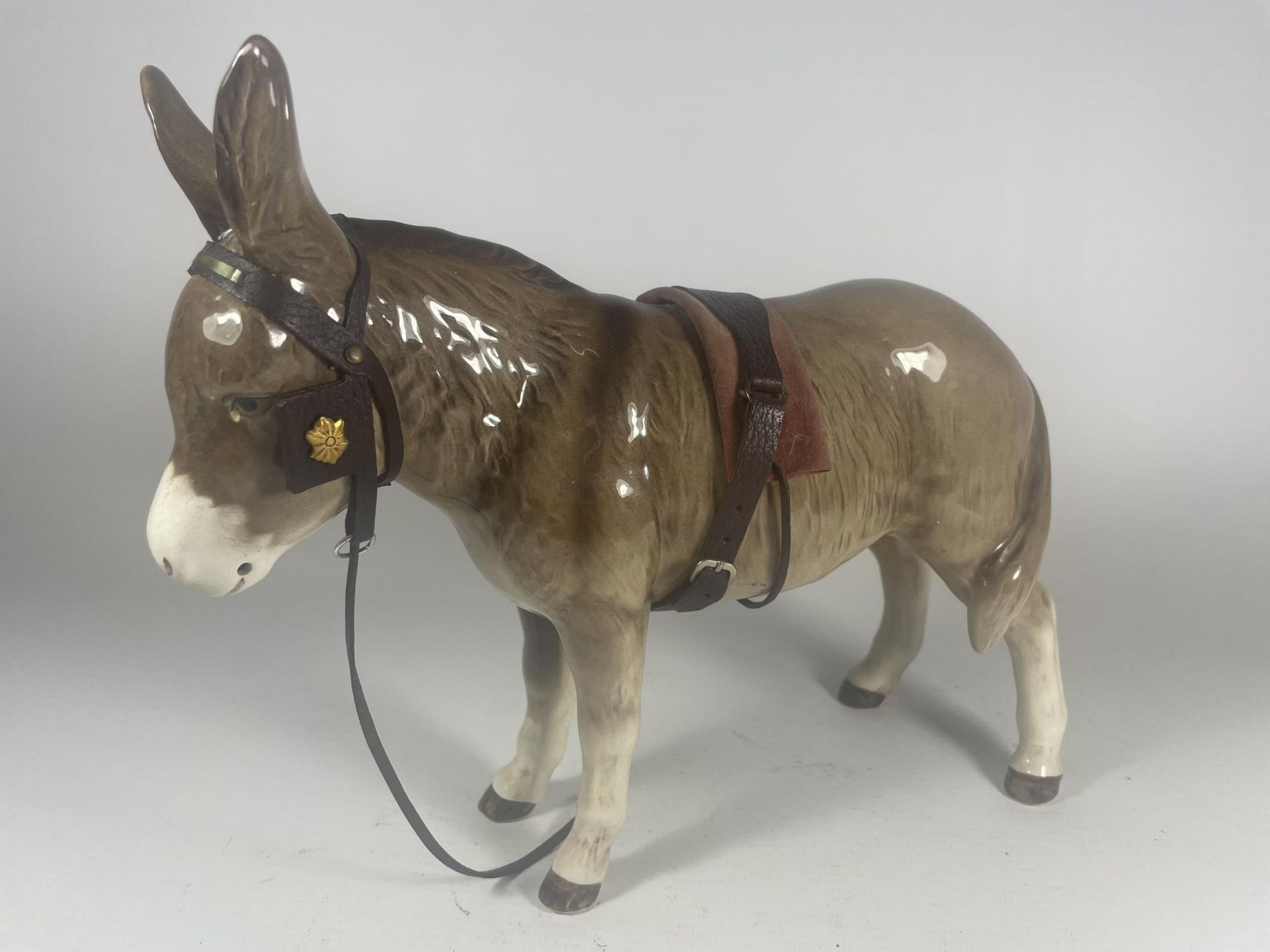 A SYLVAC DONKEY FIGURE WITH LEATHER REIGNS