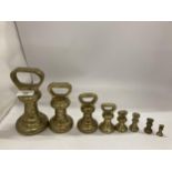 A VINTAGE GRADUATED SET OF EIGHT BRASS WEIGHTS, LARGEST 7LB, SMALLEST 1OZ
