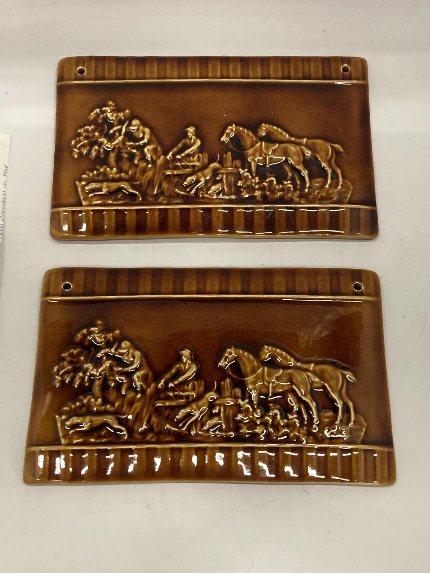 A PAIR OF LATE 19TH CENTURY TREACLE GLAZE EARTHENWARE PLAQUES WITH FOX AND HOUNDS HUNTING DESIGN, 26