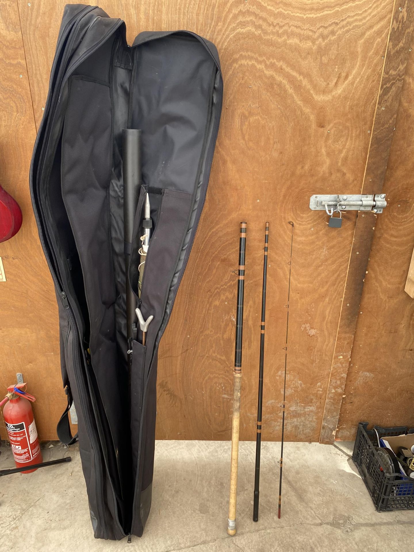 A FOX MATCH HOLDALL CONTAINING A FISHING BROLLY AND VARIOUS RODS ETC