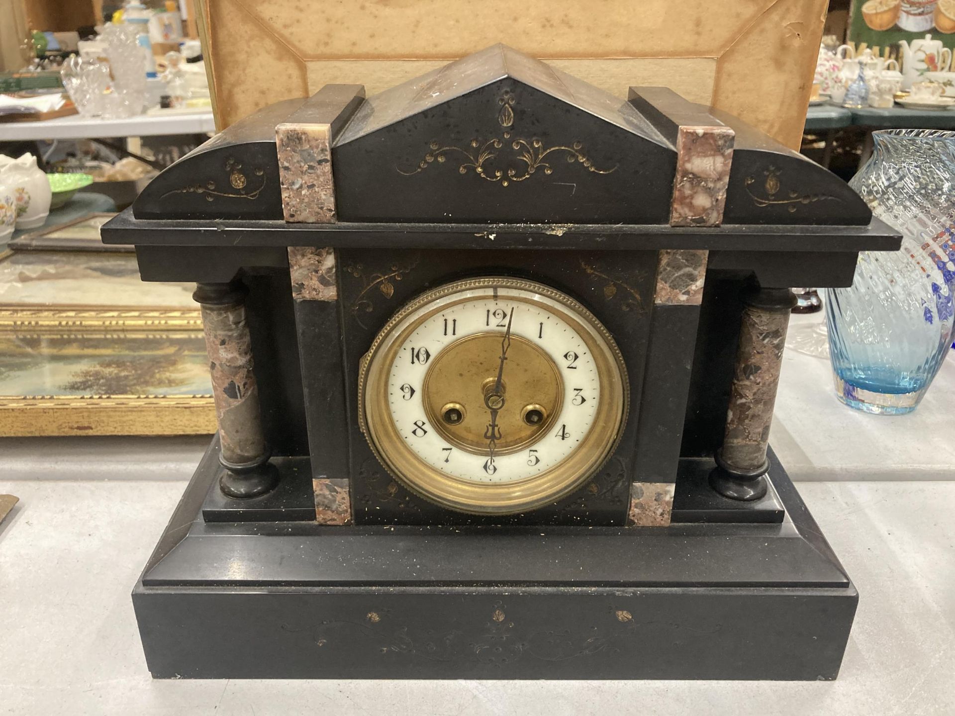 A VINTAGE BLACK MARBLE MANTLE CLOCK WITH PILLAR DECORATION VENDOR STATES IN WORKING ORDER BUT NO