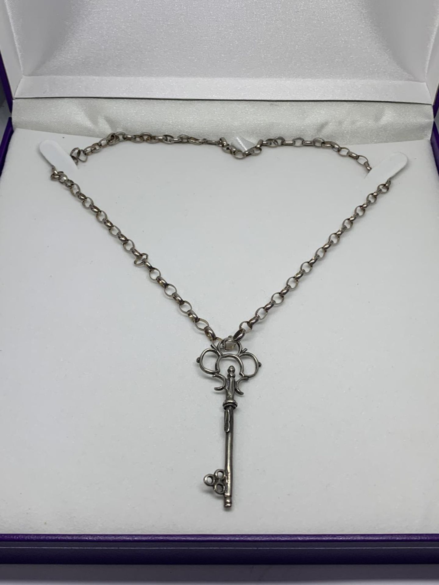 A SILVER NECKLACE WITH KEY PENDANT IN A PRESENTATION BOX