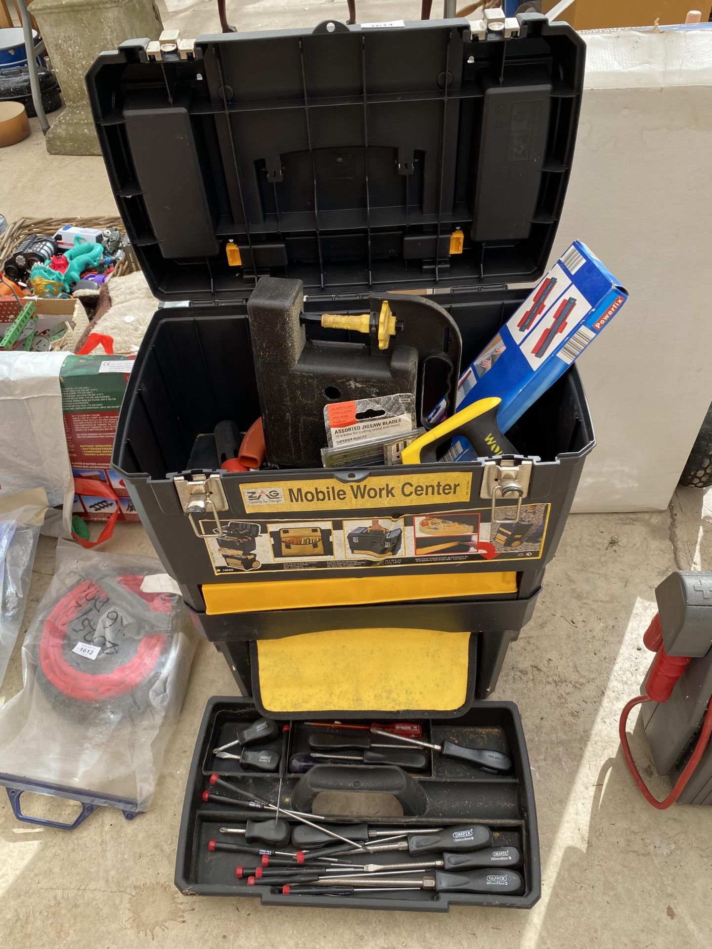 A TWO TIER MOBILE WORK CENTER WITH AN ASSORTMENT OF TOOLS TO INCLUDE SCREW DRIVERS AND SAWS
