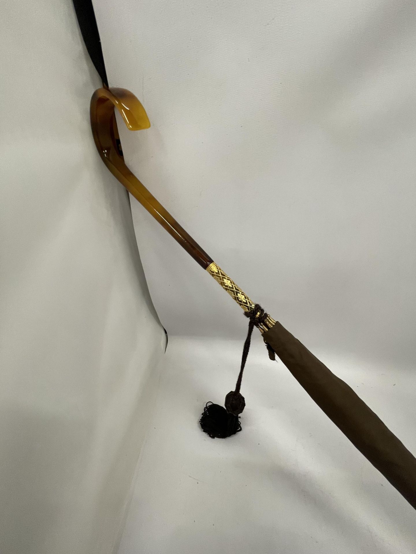 A VINTAGE PARASOL WITH DECORATIVE YELLOW METAL FERRULE AND AMBER EFFECT HANDLE - Image 2 of 3