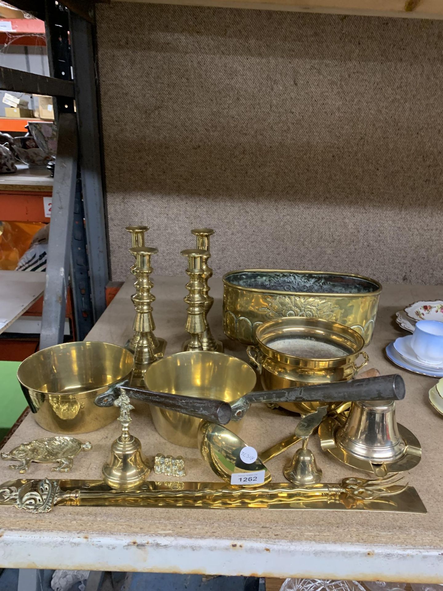 A LARGE QUANTITY OF BRASSWARE TO INCLUDE CANDLESTICKS, PLANTER, PANS, BELLS, ETC.,