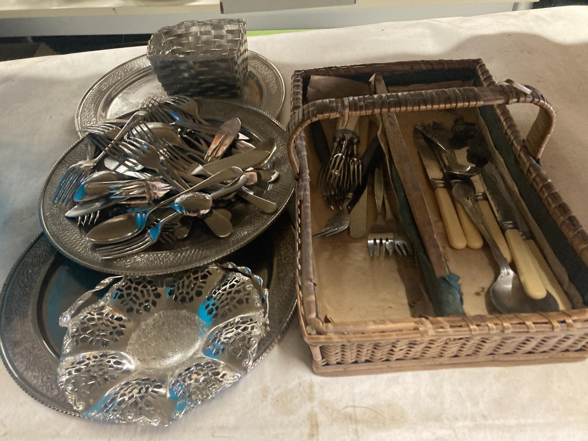 A QUANTITY OF VINTAGE FLATWARE IN A BASKET, PLUS THREE SILVER PLATED TRAYS, ETC