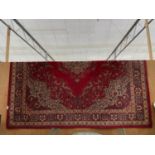 A LARGE VINTAGE RED PATTERNED RUG (3.67M X 4M APPROX)
