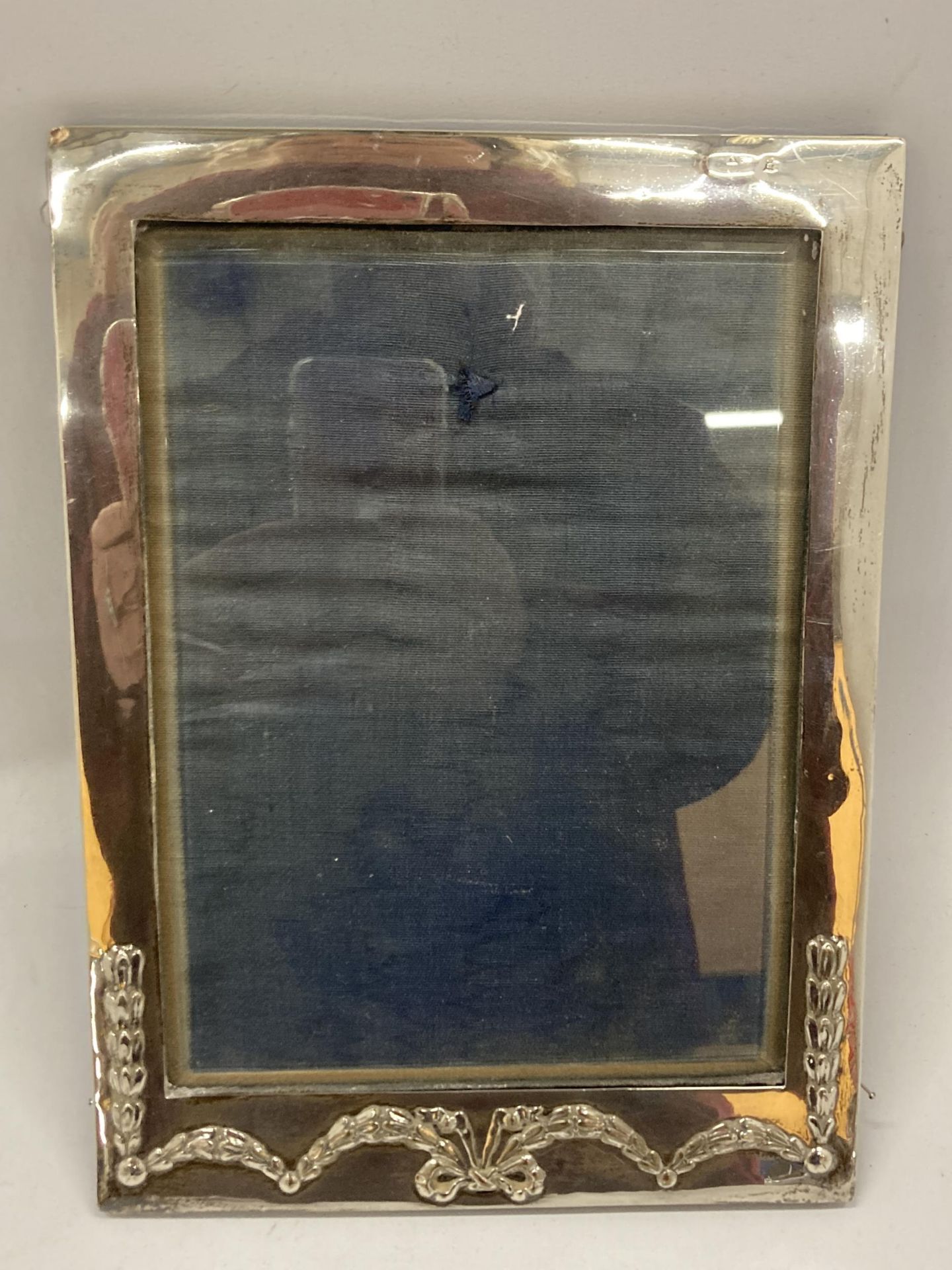A HALLMARKED SILVER RECTANGULAR PHOTO FRAME WITH FLORAL SWAG DESIGN (HALLMARKS RUBBED)