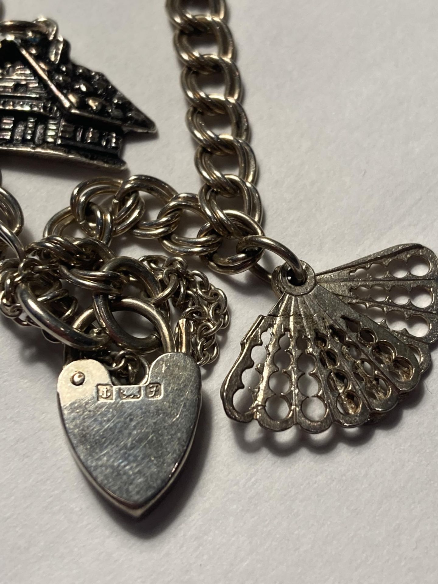 A SILVER CHARM BRACELET WITH SIX CHARMS AND A HALLMARKED BIRMINGHAM HEART PADLOCK - Image 3 of 4