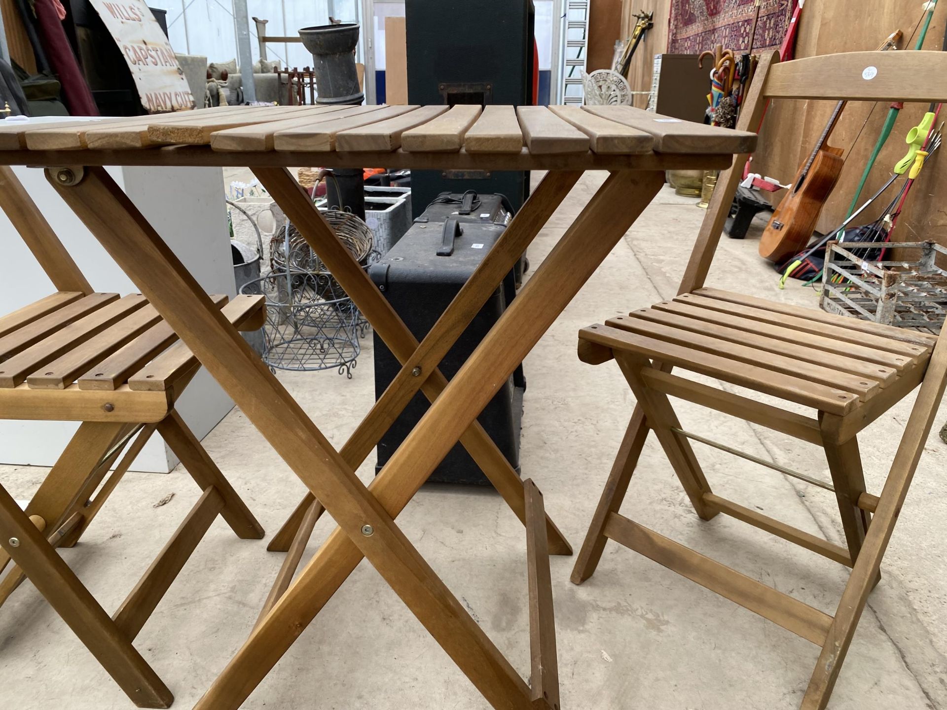 A TEAK FOLDING BISTRO TABLE AND TWO CHAIRS - Image 2 of 2