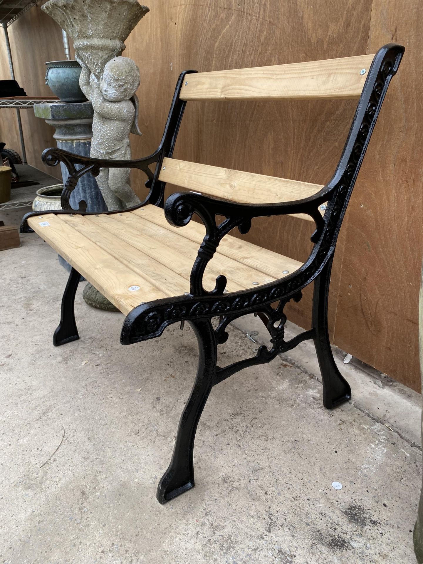 A WOODEN SLATTED WIDE GARDEN CHAIR WITH CAST IRON ENDS - Image 2 of 4