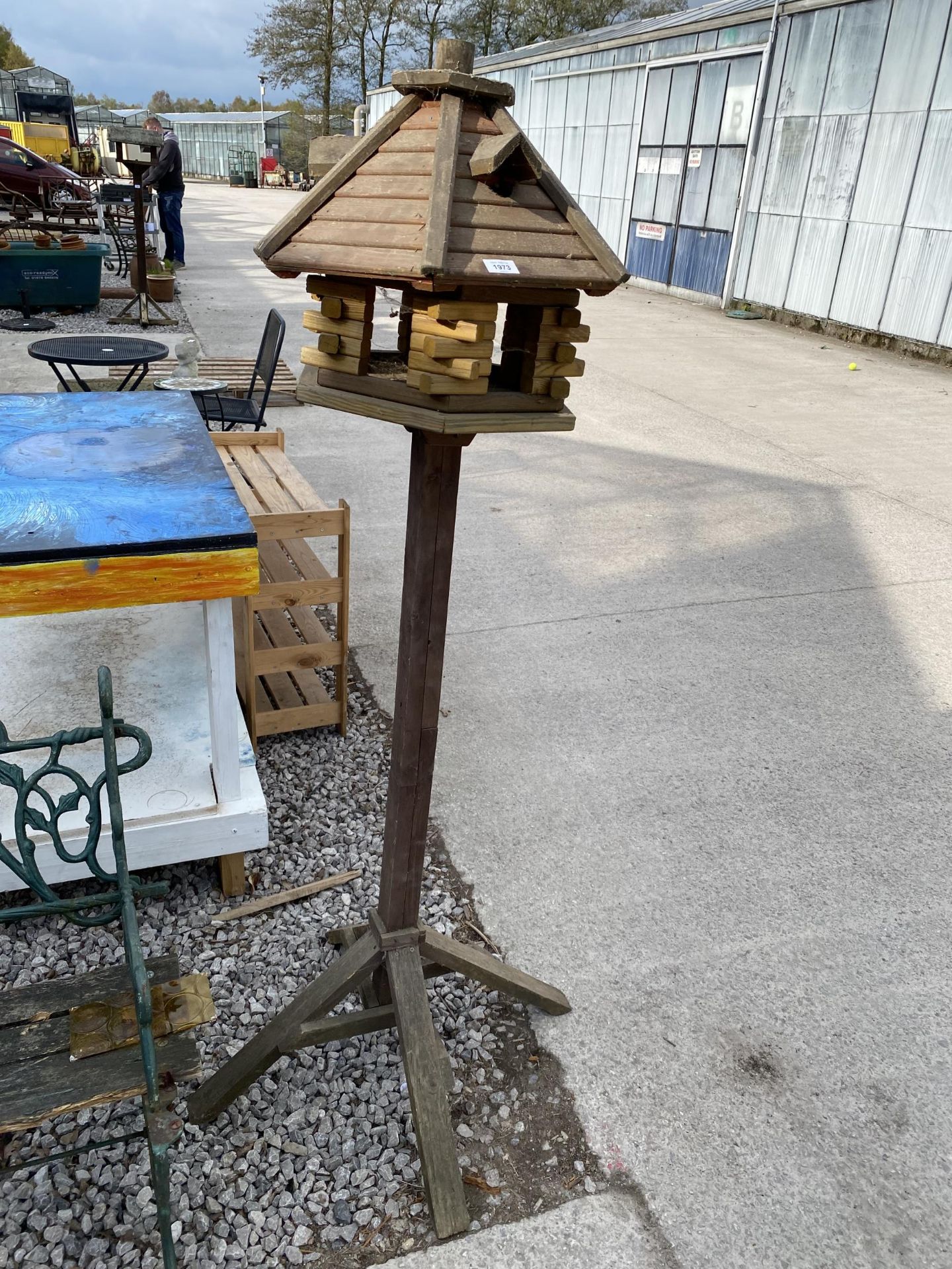 A WOODEN BIRD TABLE